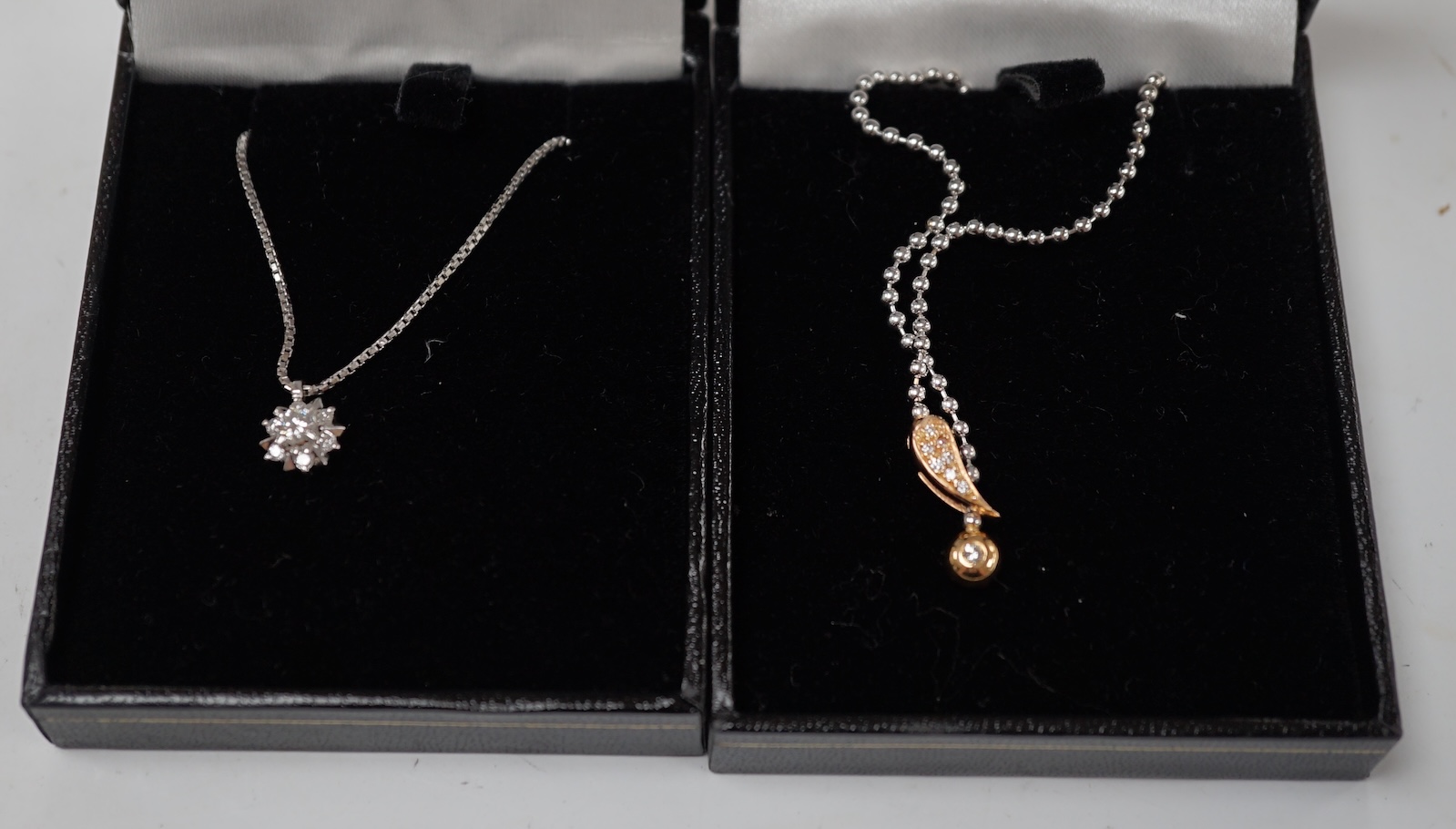 A modern white metal (stamped pt850) and diamond cluster set pendant necklace, 42cm, gross weight 6.3 grams, together with a modern 750 and diamond cluster set pendant, on a white metal ball link chain, 48cm. Condition -